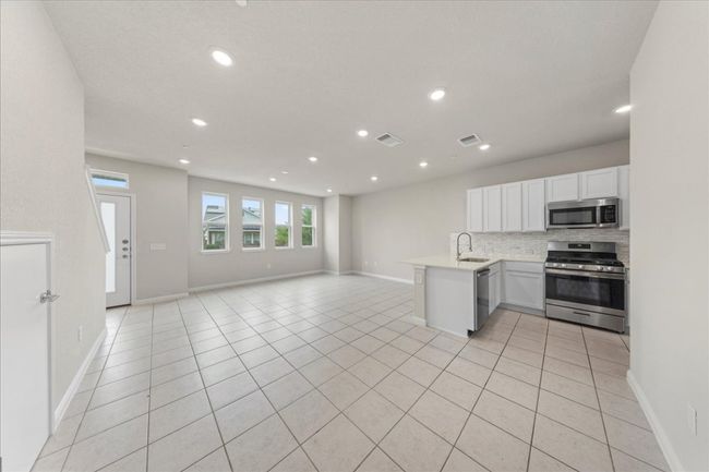 Kitchen with appliances with stainless steel finishes, recessed lighting, a sink, a peninsula, and open floor plan | Image 6