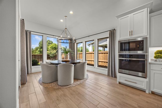 Dining space featuring a chandelier, healthy amount of natural light, recessed lighting, and light wood-style flooring | Image 10