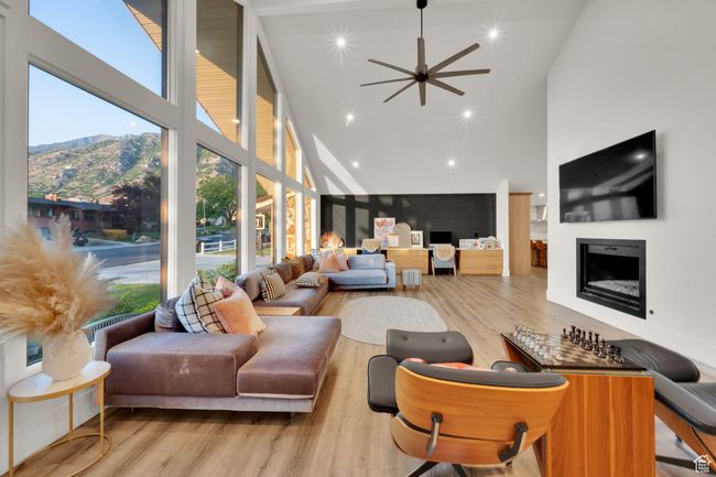 Living area featuring high vaulted ceiling, a fireplace, wood finished floors, a mountain view, and plenty of natural light | Image 12