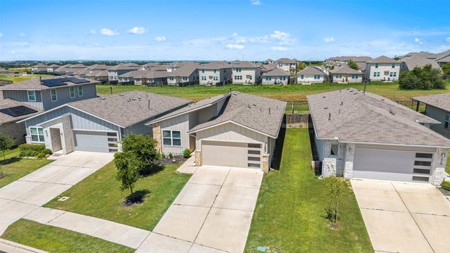 Wide aerial shot of the property, illustrating the community's layout and the home's easy access to neighboring properties. The brand new roof is also visible from this perspective. | Image 4