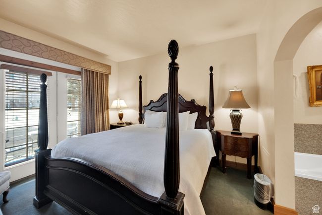 Carpeted bedroom featuring multiple windows, arched walkways, and baseboards | Image 20