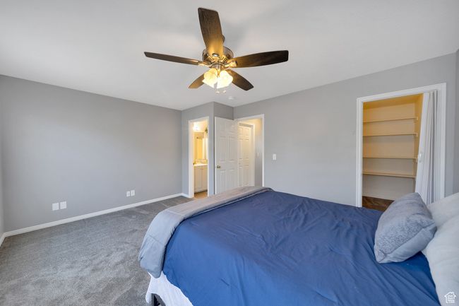 Bedroom featuring carpet flooring, a walk in closet, a ceiling fan, and connected bathroom | Image 9