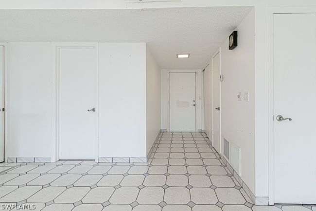 Hall featuring light tile floors and a textured ceiling | Image 3