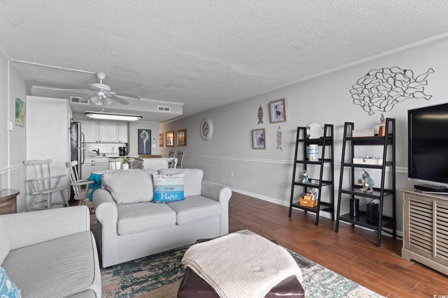 Living room featuring ceiling fan, visible vents, wood finish floors, and ornamental molding | Image 25