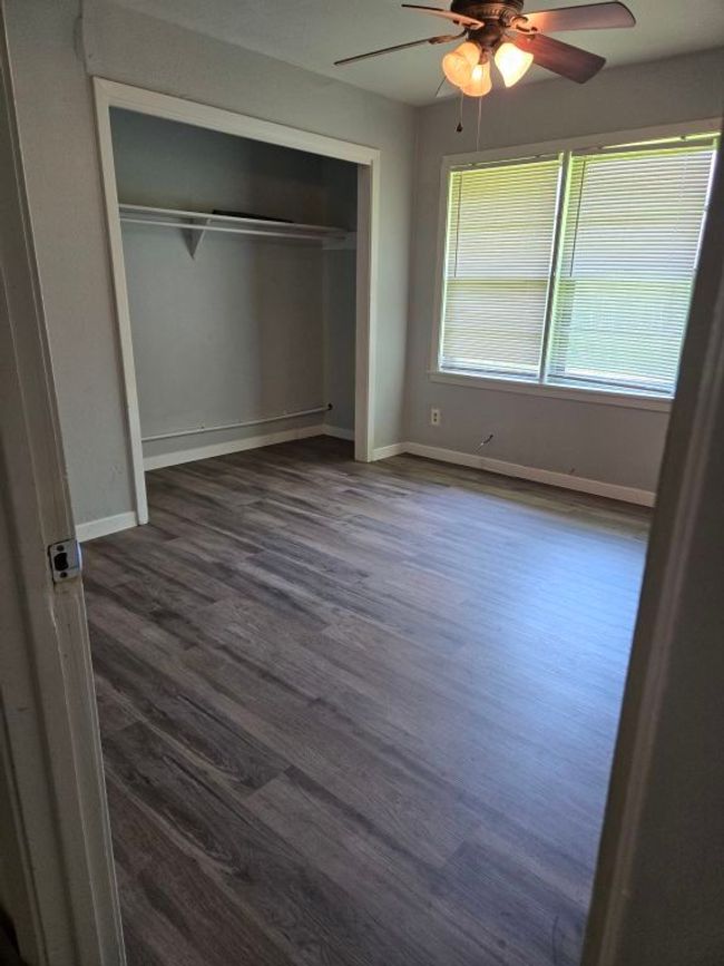 Unfurnished bedroom with dark wood finished floors, a closet, and a ceiling fan | Image 16