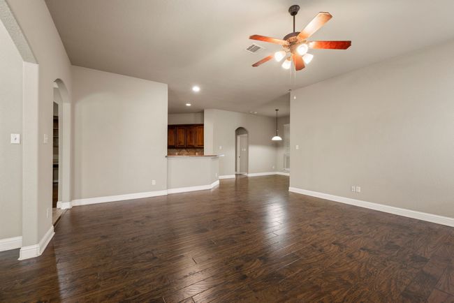 Unfurnished living room featuring recessed lighting, visible vents, arched walkways, baseboards, and ceiling fan | Image 6