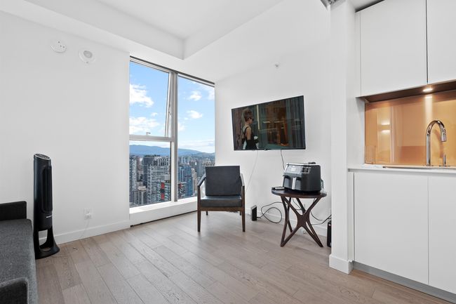 Living area featuring light wood-style flooring, a wall of windows, and baseboards | Image 9
