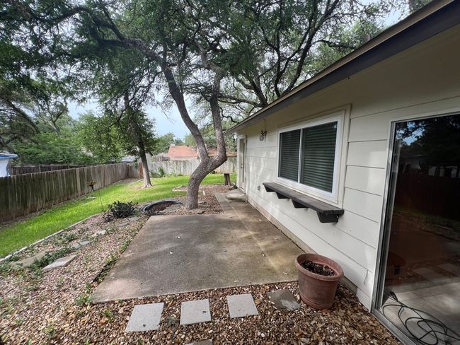 Fenced backyard with a patio area | Image 12