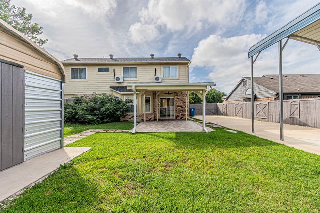 Rear view of house with a patio, a fenced backyard, and brick siding | Image 34