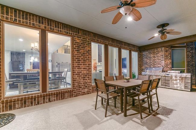 The backyard features a covered patio with dual ceiling fans, providing a comfortable space that extends to the pool area and additional outdoor space. Perfect for enjoying the outdoors in style and comfort.There’s plenty of space for outdoor dining or entertaining guests, making it the perfect area for hosting gatherings or enjoying a meal al fresco. | Image 6