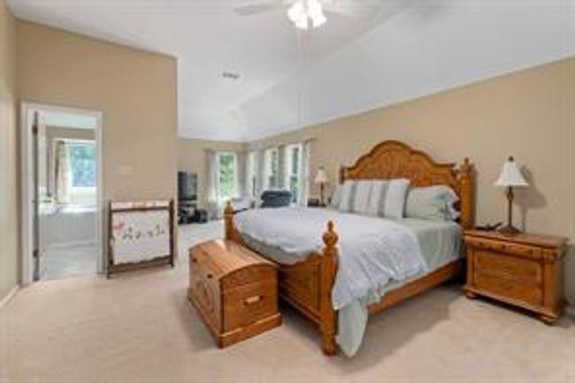 Bedroom featuring carpet floors, multiple windows, and vaulted ceiling | Image 22
