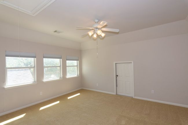 Empty room with baseboards, attic access, a ceiling fan, visible vents, and light colored carpet | Image 17