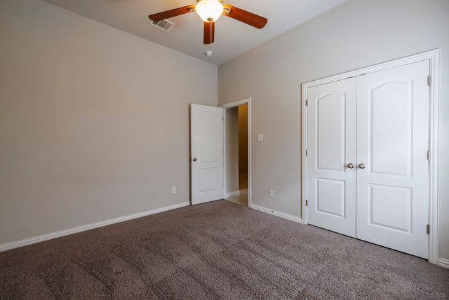 Unfurnished bedroom with carpet, ceiling fan, and a closet | Image 20