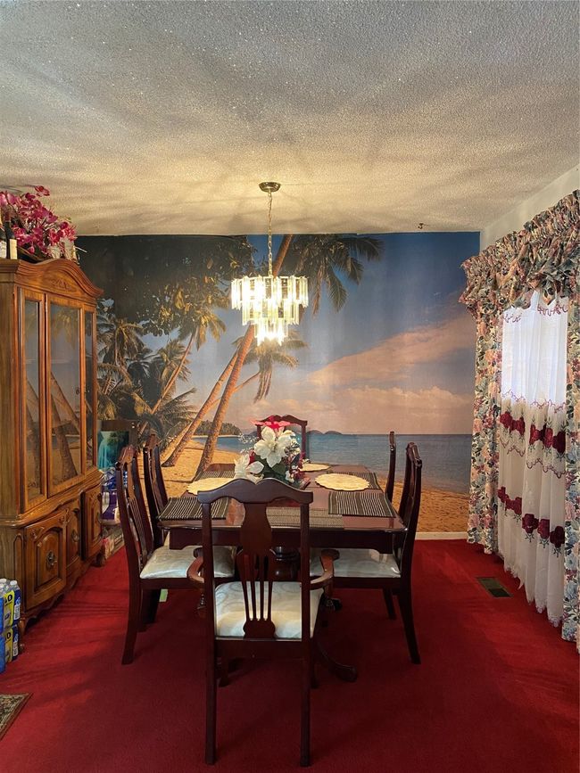 Carpeted dining room featuring a textured ceiling and a chandelier | Image 4