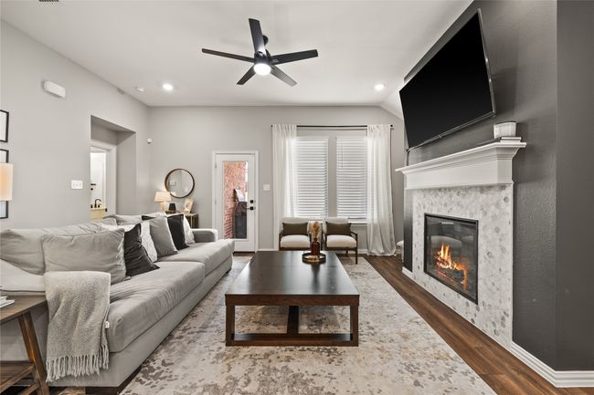 A Family Room That Truly Earns Its Name With Fireplace and View of Backyard. | Image 11