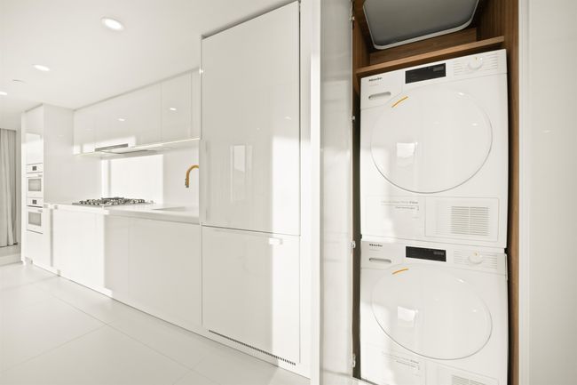 Clothes washing area featuring recessed lighting, a sink, light tile patterned floors, stacked washer and clothes dryer, and laundry area | Image 4