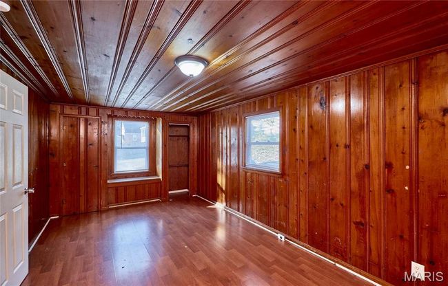 Unfurnished room featuring wood ceiling, wood-type flooring, and wooden walls | Image 5