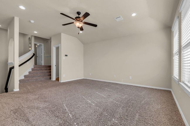 This spacious game room is the ultimate hangout spot, perfect for family fun and entertaining guests. With plenty of room for a pool table, gaming setup, or cozy lounge seating, it’s designed for relaxation and recreation. Stairs lead to a third story media room where the fun continues. | Image 29
