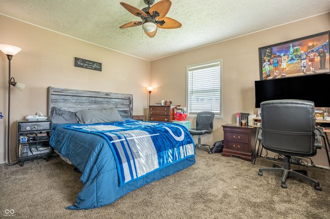 carpeted bedroom with a ceiling fan and a textured ceiling | Image 16