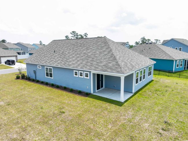 Rear view of property featuring a shingled roof, a patio, and a residential view | Image 6