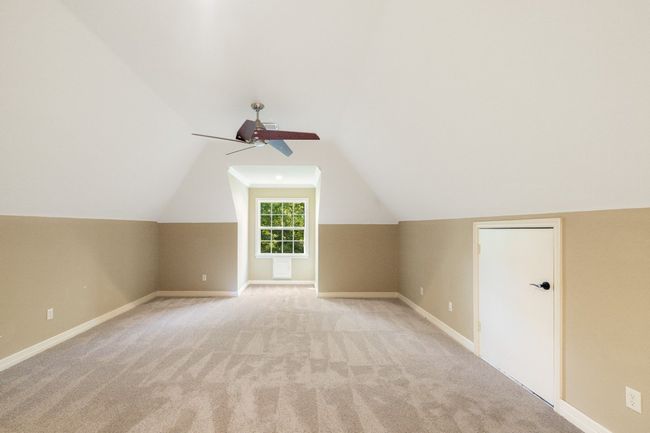 Bonus room featuring lofted ceiling, a ceiling fan, baseboards, and light carpet | Image 30