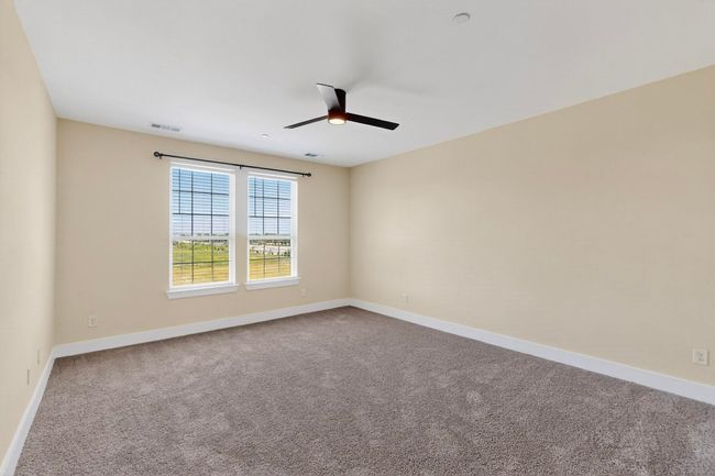 Unfurnished room with ceiling fan and dark carpet | Image 18