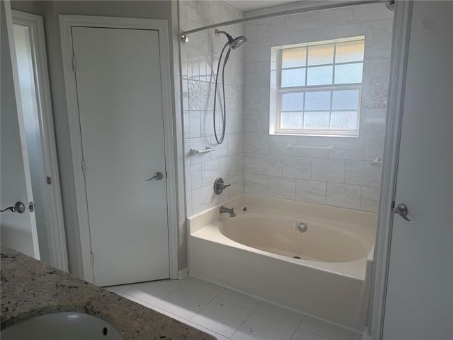 Full bathroom featuring tile patterned floors and shower / tub combination | Image 7