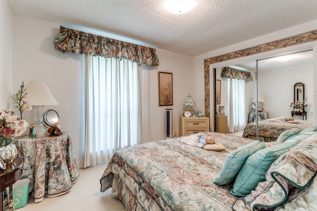 Bedroom with multiple windows, a textured ceiling, carpet flooring, and a closet | Image 16