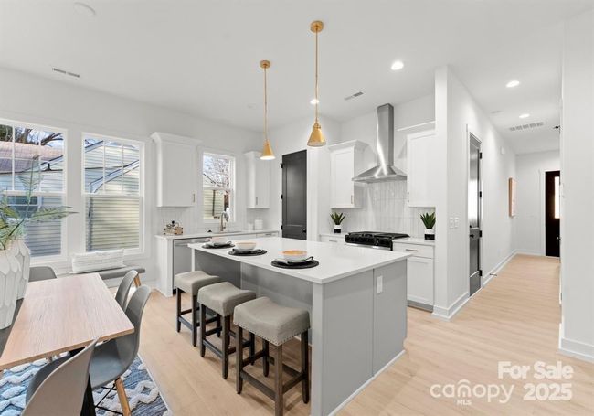 This Gourmet kitchen features a water fall edge countertop kitchen island and soft close drawers. Gas stove with convection oven and microwave drawer in the island. | Image 6