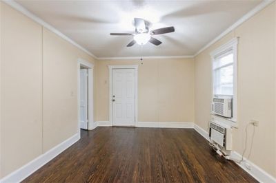 Living room featuring dark hardwood floors, cooling unit, ceiling fan, and crown molding | Image 3