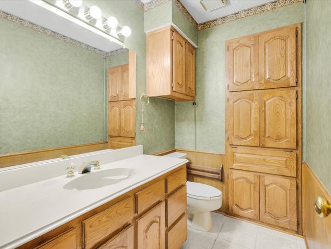 Large half bath is perfect for guests and includes storage cabinets. | Image 22