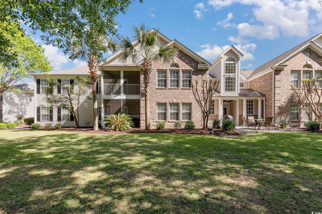 Back of house with brick siding, a lawn, and a patio area | Image 34