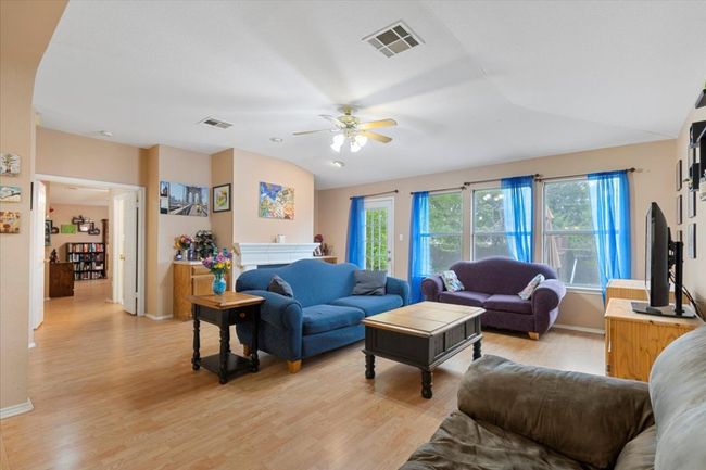 Living area featuring a ceiling fan, light wood-style floors, baseboards, and vaulted ceiling | Image 15