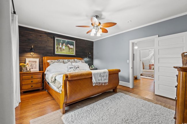 Bedroom featuring wood finished floors, ornamental molding, and a ceiling fan | Image 15