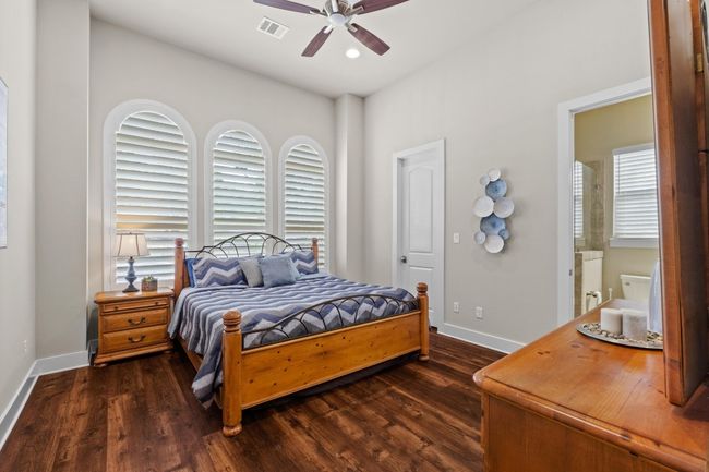 Bedroom with baseboards, visible vents, and dark wood finished floors | Image 21