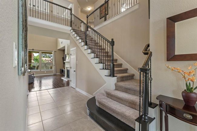 The elegant staircase features wrought iron spindles adding a timeless touch. | Image 6