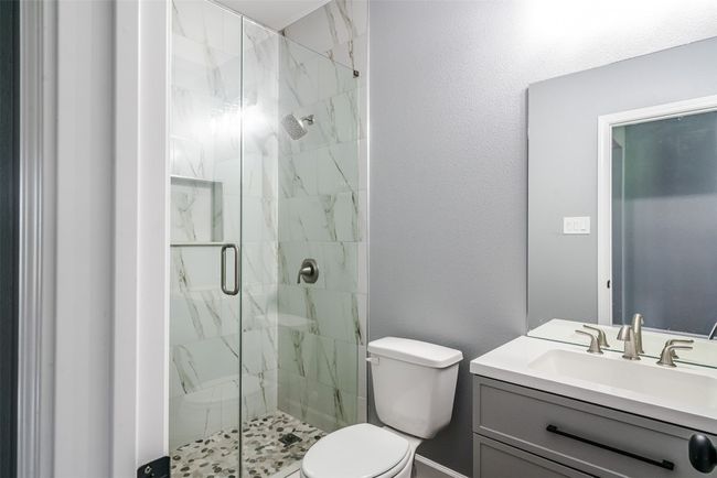 Full bathroom featuring toilet, a marble finish shower, and vanity | Image 24