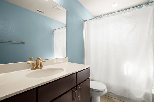 The guest bathroom is thoughtfully designed with a shower/tub combo and a spacious vanity, providing both functionality and style for guests. | Image 19