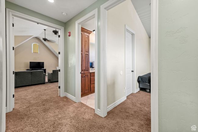 Corridor featuring baseboards, light carpet, and lofted ceiling | Image 38