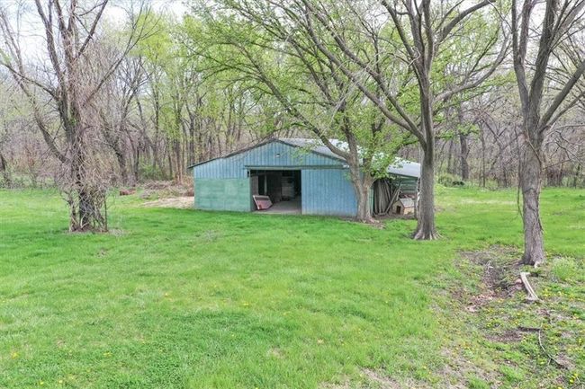 View of yard featuring a view of trees and an outbuilding | Image 7