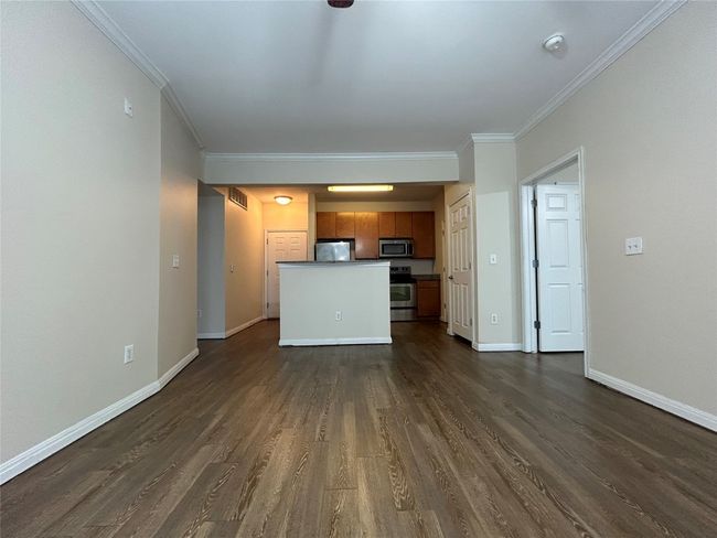 Unfurnished living room featuring ornamental molding, dark wood finished floors, visible vents, and baseboards | Image 20