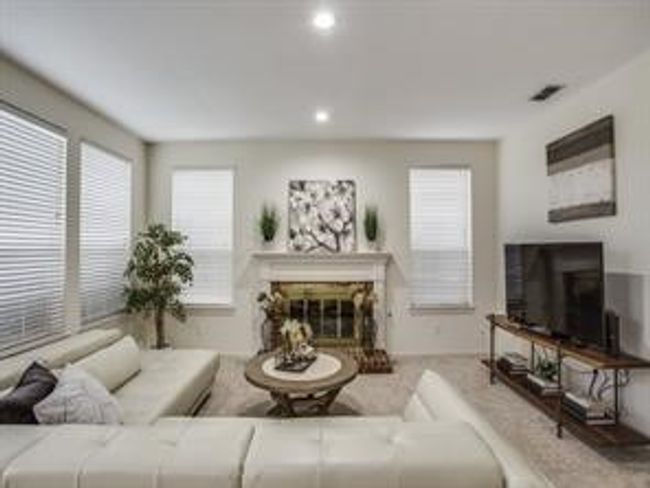 Living area with a glass covered fireplace and recessed lighting | Image 13