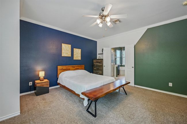 Bedroom with crown molding, baseboards, carpet, ceiling fan, and connected bathroom | Image 16