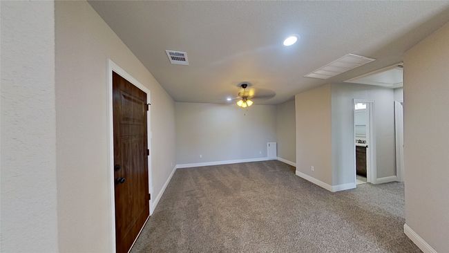 Spare room featuring a ceiling fan, carpet, visible vents, and baseboards | Image 11