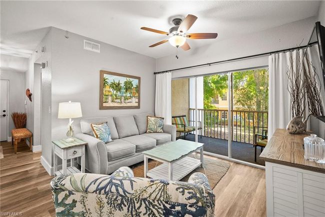 Living room with a ceiling fan, wood finished floors, baseboards, and visible vents | Image 8