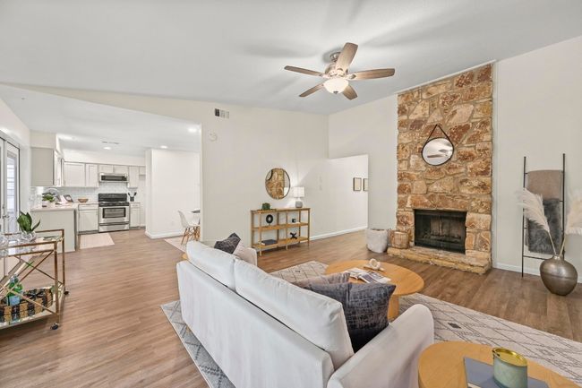 The center piece of the living room is a charming stone inset wood burning fireplace. | Image 8