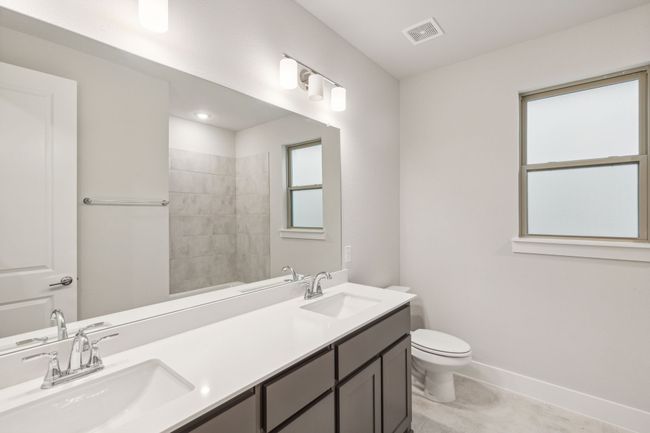 Secondary Bathroom featuring double vanity and a tile shower | Image 20