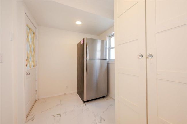 Kitchen with freestanding refrigerator, marble finish floor, baseboards, and recessed lighting | Image 9