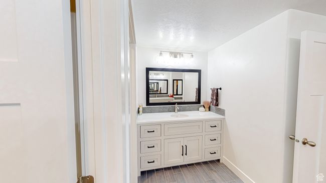 Bathroom with wood tiled floor, vanity, and a textured ceiling | Image 33