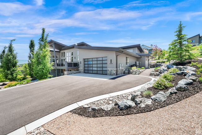 Contemporary home with driveway, a garage, and stone siding | Image 100